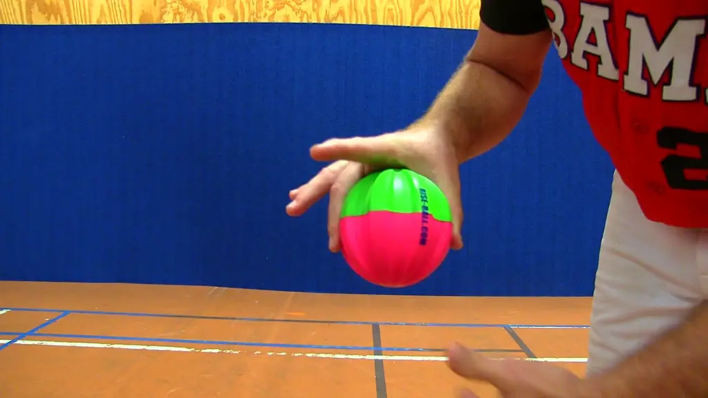 A pitcher's hand holding an EZ-Riseball, fingers set into the moulded grooves